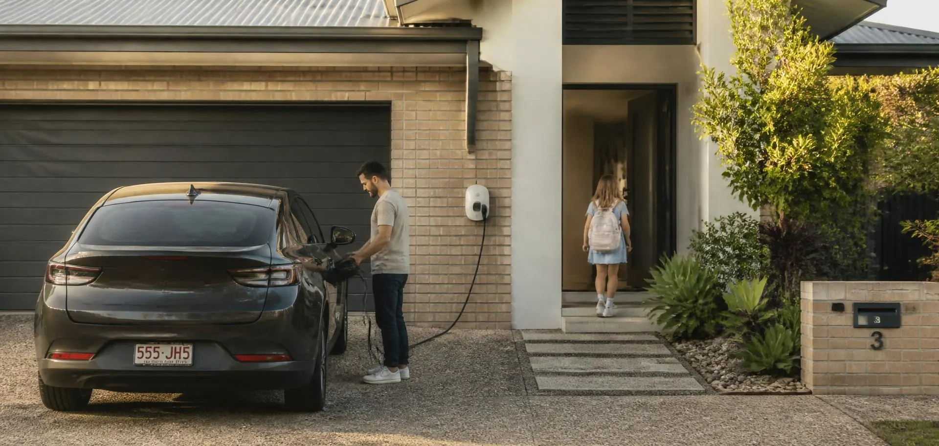 Family arriving home at a Perth house in the late afternoon and plugging in their electric car